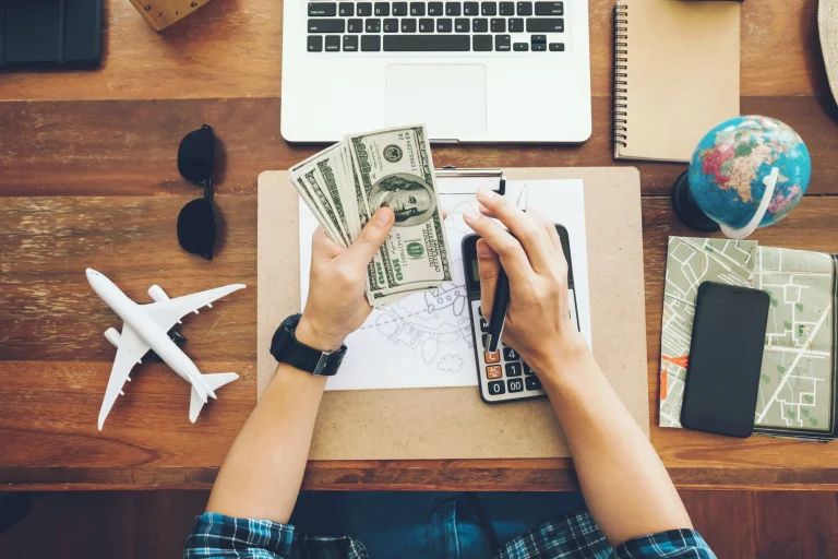 Top-view-tourist-counting-cash-to-spend-during-his-luxury-vacation-planning-budget