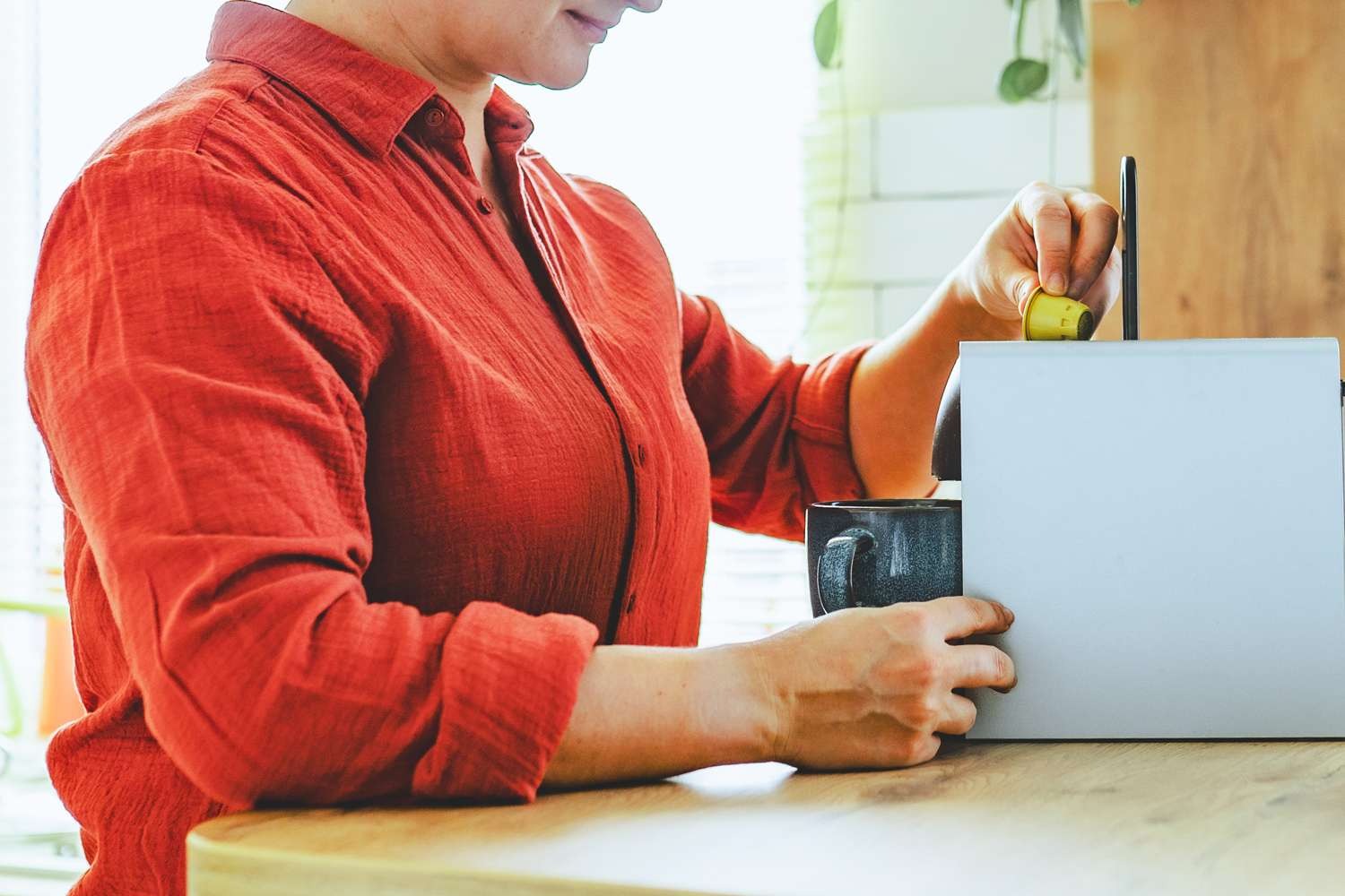 Woman-using-capsule-coffee-machi