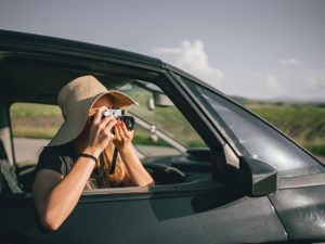 woman taking photos on a road trip